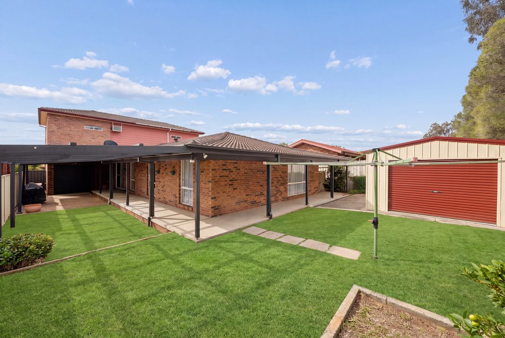 Back yard with lawn, the house and the rear shed
