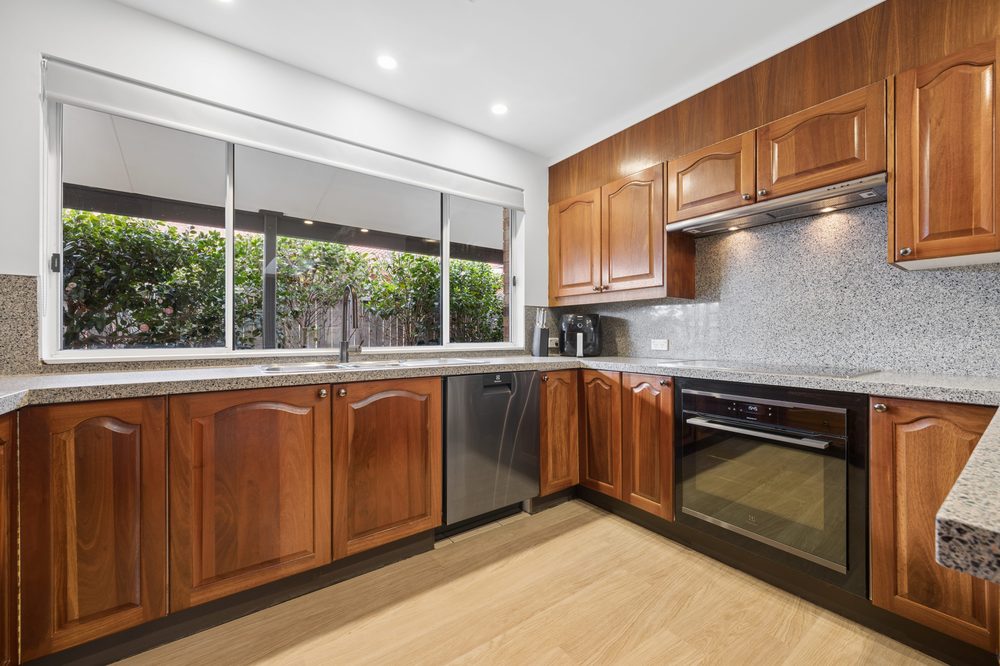 Kitchen with timber cabinetry, induction cooktop and oven