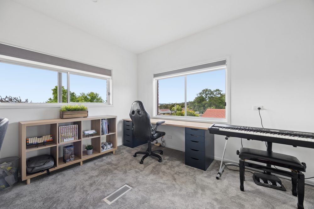 Upstairs room with a desk, keyboard and windows