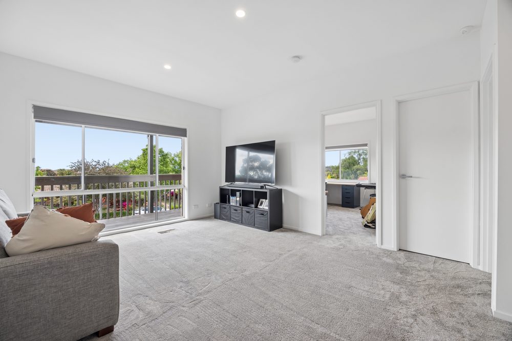 Upstairs rumpus room with a sofa and door to the deck